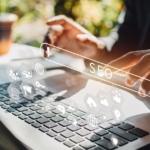 A person sits at a laptop with an SEO infographic hovering the keyboard. They're gesturing to the SEO button in the graphic.